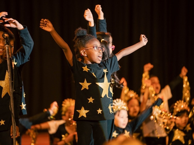 Students performing on stage in star-themed costumes