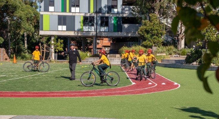 Students learning bike riding skills on the school track.